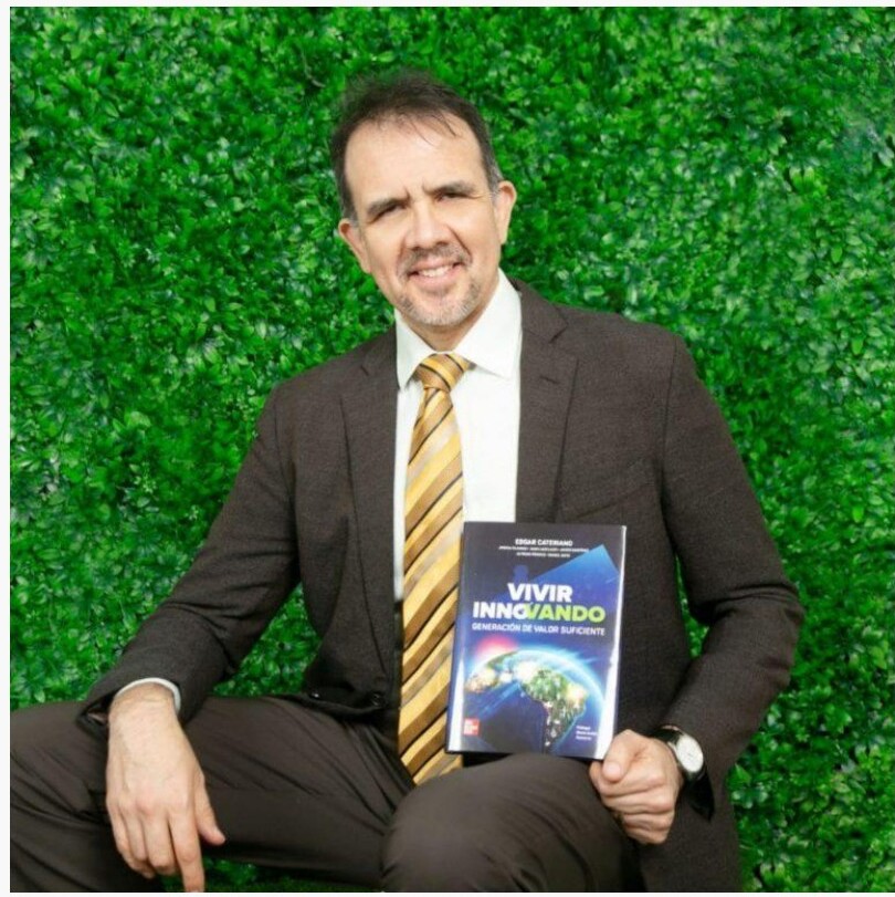 Edgar Cateriano holding the book Vivir Innovando